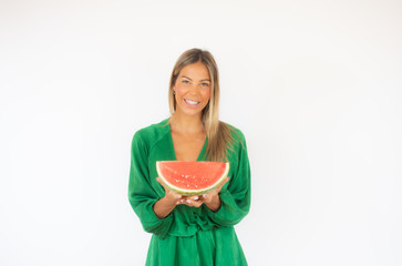 Beautiful woman in green dress with a watermelon smiling