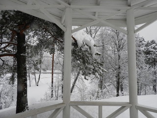 White Chinese style gazebo perched on a rock in winter in the snow