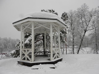 White Chinese style gazebo perched on a rock in winter in the snow
