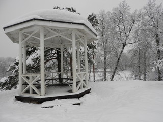 White Chinese style gazebo perched on a rock in winter in the snow