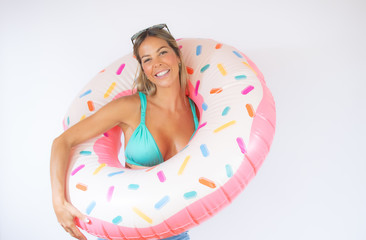 Pretty woman in bikini with a colorful float smiling