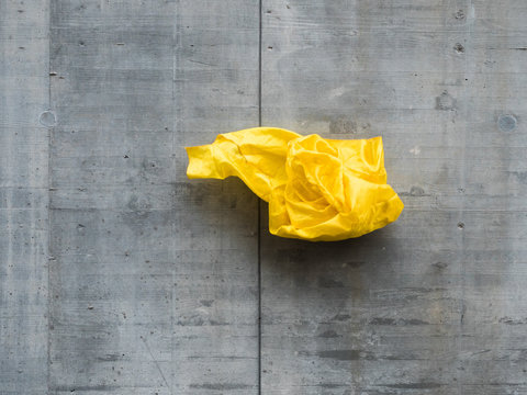 thrown yellow fabric in front of concrete wall