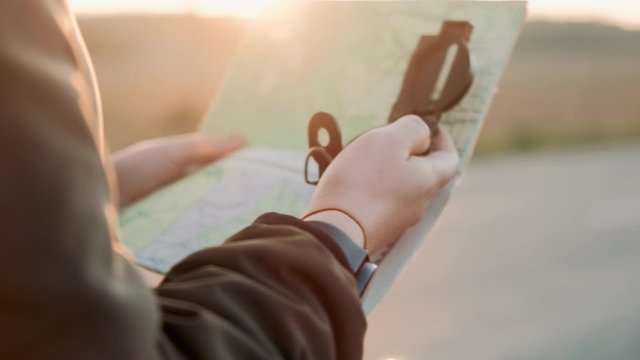 Close up hands of hiker tourist traveler man with compass looking for map route, traveling on mountain, Active lifestyle hiking enjoying vacation travel tourism adventure landscape nature. Travelling 