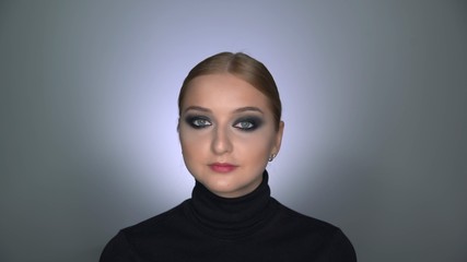 Fototapeta premium Beautiful woman with makeup smoky eyes posing at the camera