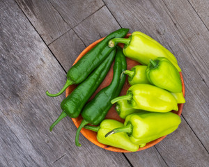 Plate with yellow and green peppers on a wooden table top view