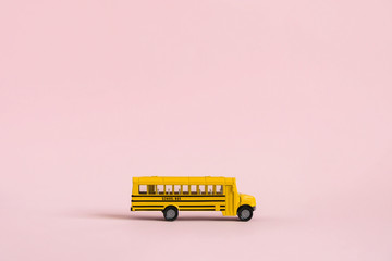 Back to school concept. Traditional yellow school bus on pink background. Transfer to school....