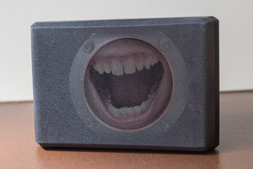 Open mouth yelling inside the speaker. Communication concept.