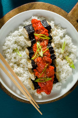 fried tofu wrapped in nori with tomato-coconut sauce and rice for sushi. vegan modern cuisine
