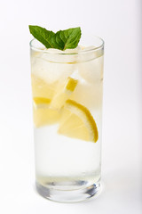 A sweaty glass of lemonade with mint on a white background