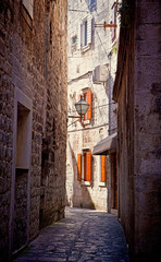 Fototapeta na wymiar Croatia - Narrow medieval cobbled street in Trogir center, antique Dalmatian city founded 4000 years ago.