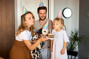 cheerful positive owners celebrate dog's birthday, they congratulate, happy to have such family member, in party hats