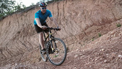 Plakat Man is riding bicycle, on the background of rocky trail in mountain area bike on trail at evening.mountain bike racing.healthy lifestyle.xtreme sports.vintage tone.selective focus.