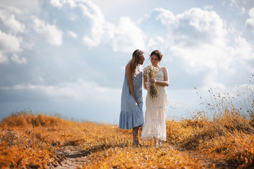 Two girls in dresses in autumn field