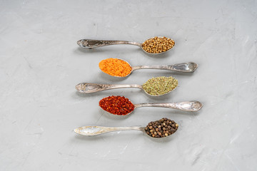 Variety of herbs and spices on slate background.