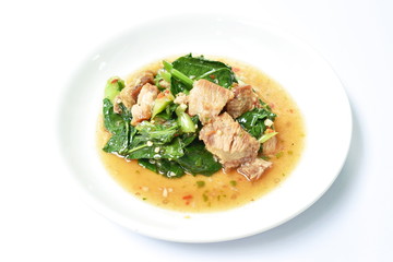 spicy fried Chinese kale with slice crispy pork in soybean and oyster sauce on plate
