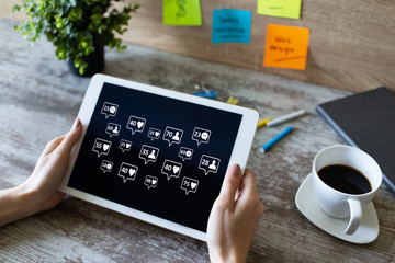 SMM, Social media marketing concept. Likes, comments and new follower icons on device screen.