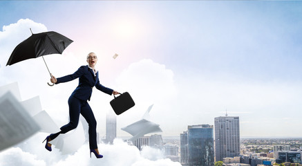 Young businesswoman walking with umbrella