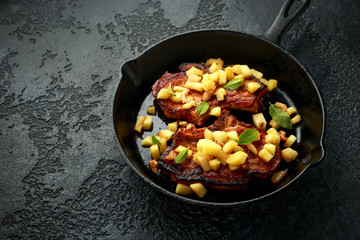 Roasted Pork chops with caramelized apples, walnuts and sage in a cast iron pan