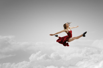 Fototapeta na wymiar Female dancer against sky background