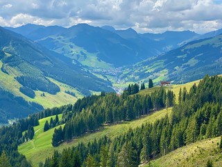 Aerial view on cozy hut with mountain panorama from Saalbach to Hinterglemm in the Alps in Austria on a sunny summer day.