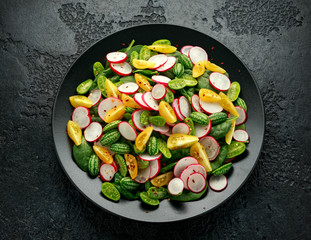Cucamelon salad with radish, tomato, spinach and mustard dressing. Healthy food.