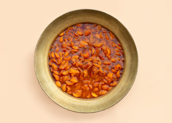 Copper Bowl with hot apricot or peach jam. Top view.