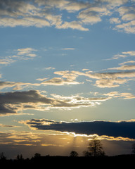 The setting sun hidden behind the clouds