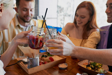 happy caucasian friends did not meet each other in a long time, hold meeting in restaurant or bar, have meal, discuss news