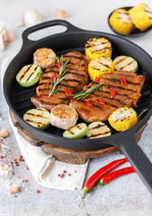Grilled meat with vegetables in a cast iron grill pan. Grilled pork with grilled vegetables
