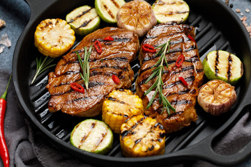 Grilled meat with vegetables in a cast iron grill pan. Grilled pork with grilled vegetables