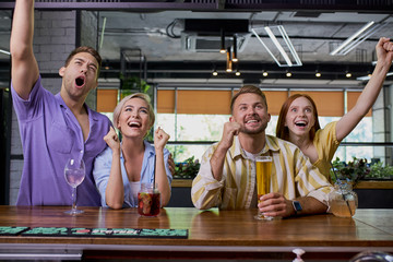 happy young caucasian friends drinking beer, watching sport game or football match at bar or pub, have fun. people, leisure, friendship and entertainment concept