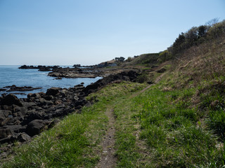 A view of the trail along the ocean with blue sky. The Michinoku Coastal Trail in Aomori...