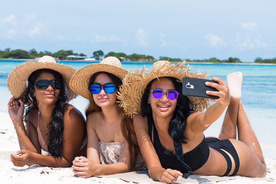 multiracial women friends together enjoy taking selfie photo at caribbean beach Los Roques venezuela