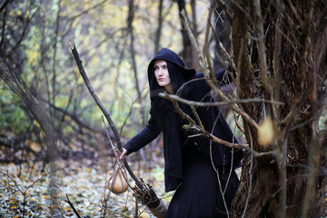 A woman in a witch suit in a forest