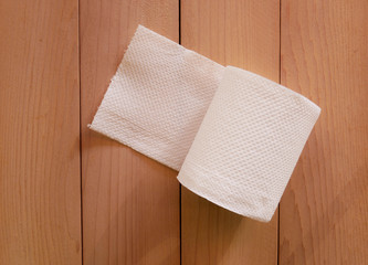 Simple toilet paper on wood background.