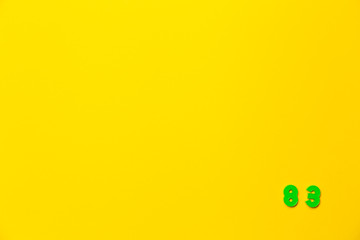 A green plastic toy number eighty-three is located in the lower right corner on a yellow background