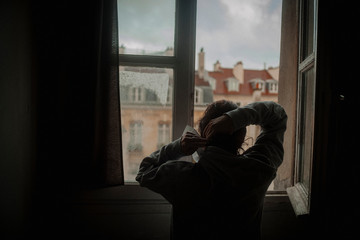 Depressive junge Frau blickt aus Fenster