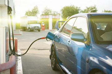 fuel pump inserted in the sport car on the fuel station, pour gasoline oil in the vehicle