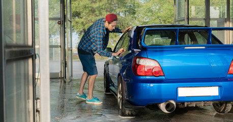 male driver cleaning the car inside the self wash station box