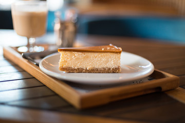 Delicious caramel cheesecake on a plate on a wooden table in a cafe