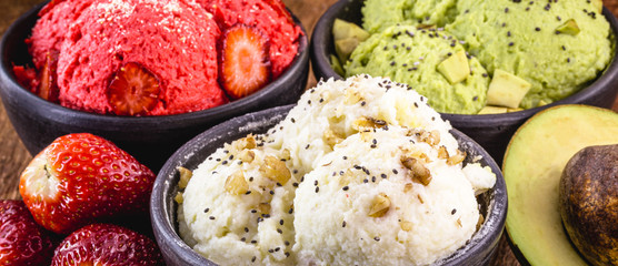 homemade strawberry, banana and avocado ice creams, without milk, vegan. With fruits around, space for text.