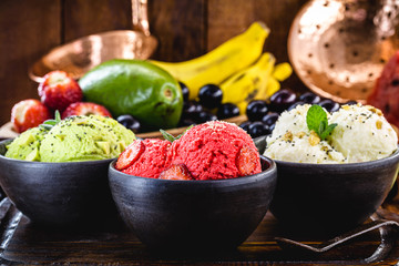 vegan ice cream made with organic fruits, with tropical fruits in the background, flavors of strawberry, banana, jabuticaba and avocado