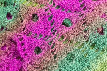 close-up handmade multicolor crochet background in green and purple with double crochet stitches and chain stiches