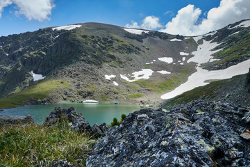 blue alpine lake formed from a glacier on top of a mountain