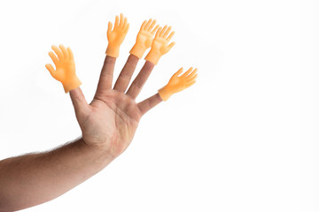 Hand on a white background on her fingers is wearing a toy in the shape of a hand. Concept. No...