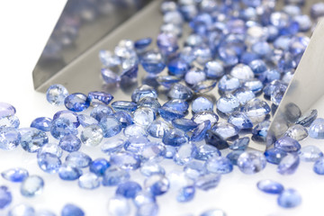 Precious blue sapphires on a jeweler's shovel. Precious polished stones. Set of many stones.