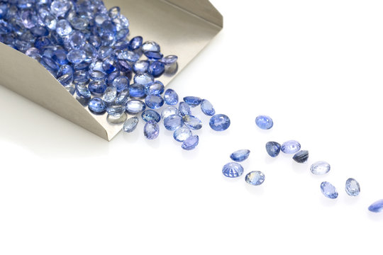 Precious blue sapphires on a jeweler's shovel. Precious polished stones.