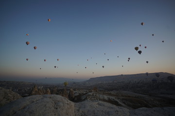 Hot air balloon flying over rock landscape at Cappadocia Turkey