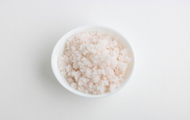Fototapeta na wymiar Pink salt in a white bowl on a white background