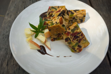 delicious sliced fruit cake with mixed fruit on wooden table